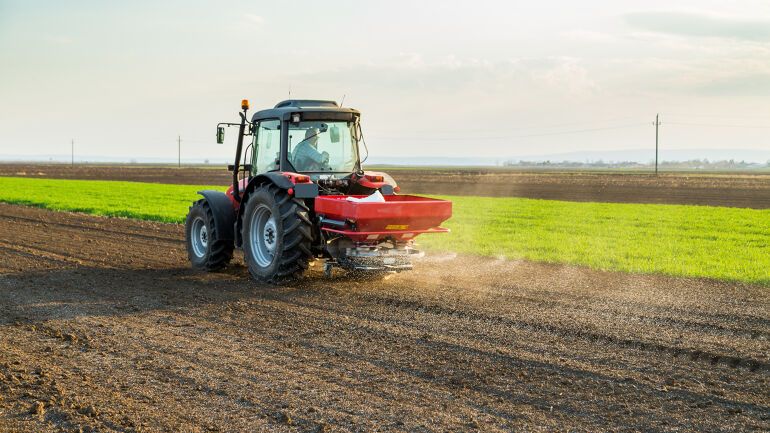 Traktor gjødsler en åker